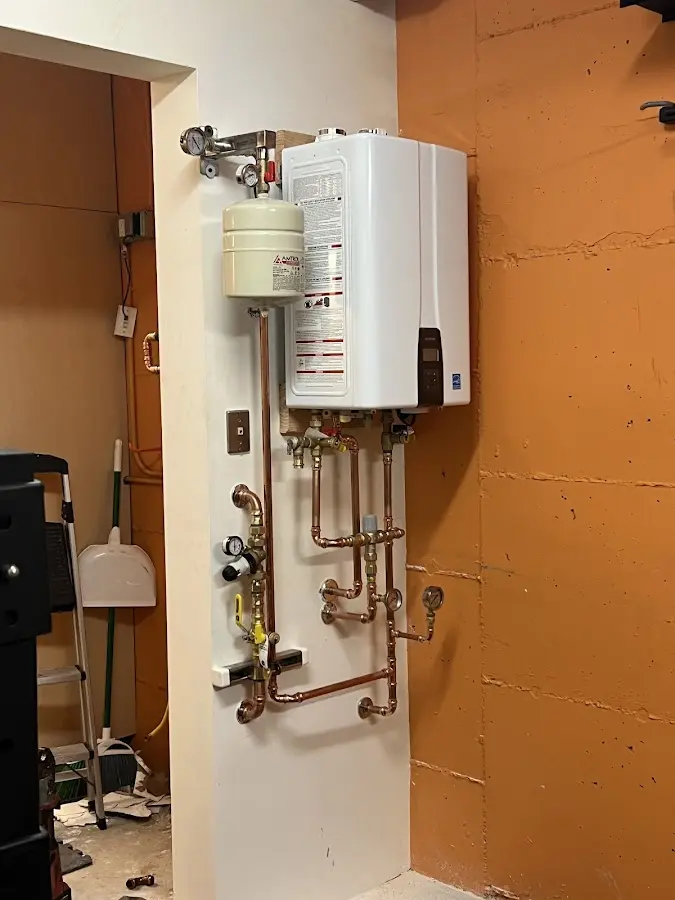 Plumbing technician inspecting water heater connections in Christiansburg